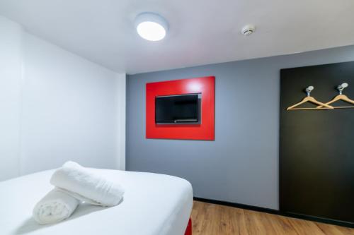 a bedroom with a bed and a tv on a wall at easyHotel Newcastle in Newcastle upon Tyne