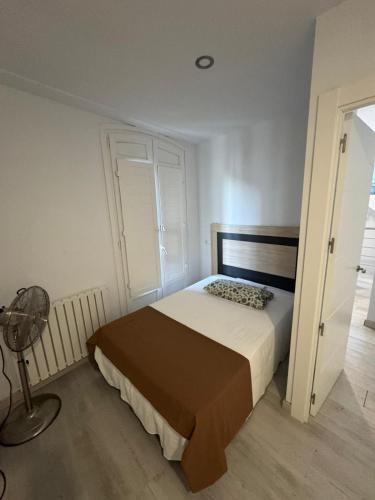 a small bedroom with a bed and a fan at El Balcón de la Nubla in Cazorla