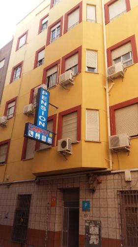 a yellow building with a sign in front of it at Pensión Campoy in Murcia