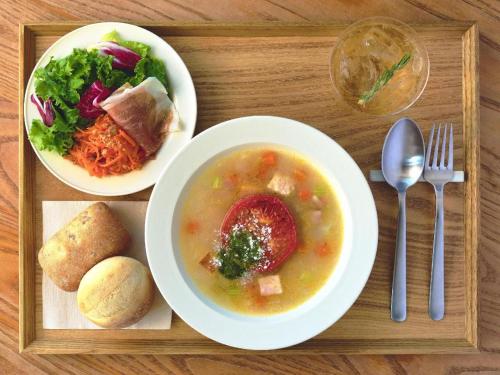 a tray with a bowl of soup and a salad at Hotel Edit Yokohama in Yokohama