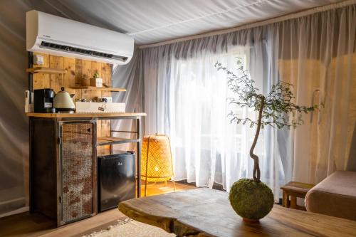a living room with a table and a window at Rom Farm by Glow - חוות רום in Kammon
