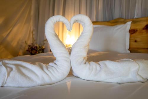 two towel swans making a heart on a bed at Rom Farm by Glow - חוות רום in Kammon
