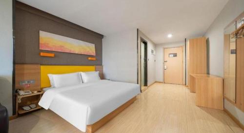 a bedroom with a large white bed in a room at 7 Days Premium Xi'an Dayan Tower Xiaozhai Metro Station in Xi'an