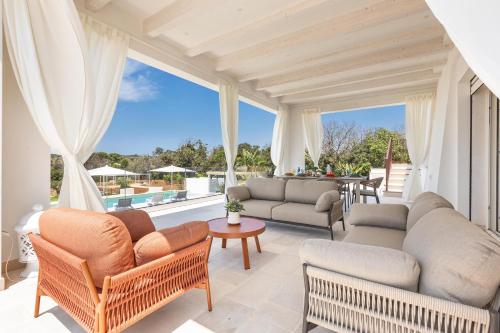 a living room with furniture and a large window at Villa Demetra by SalentoInVacanzaCOM in Marina di Pescoluse