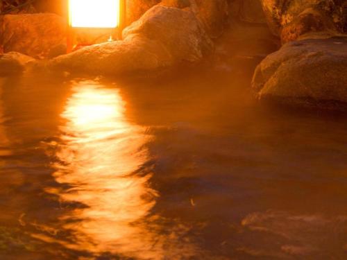 a river with a light on the side of it at Yuzawa New Otani in Yuzawa