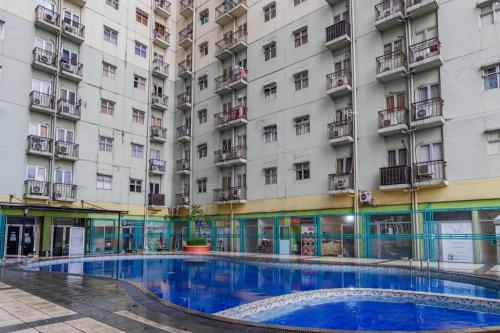 a large building with a large swimming pool in front of it at OYO 94150 Gateway Apartment Pasteur By Eldian in Bandung