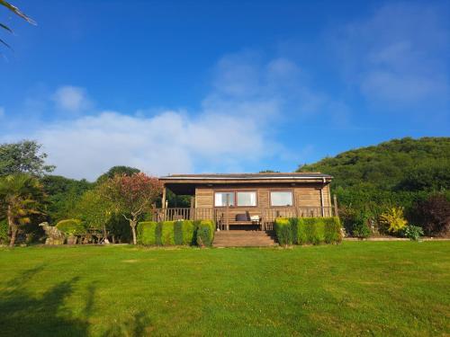 a house with a green yard in front of it at The Cabin in St Austell