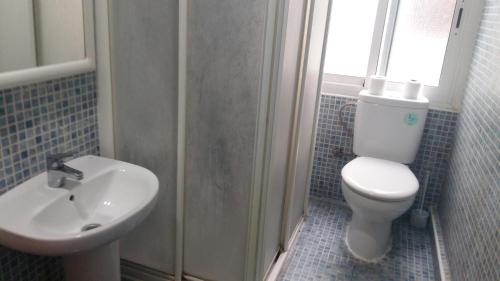 a bathroom with a toilet and a sink at Pensión Campoy in Murcia