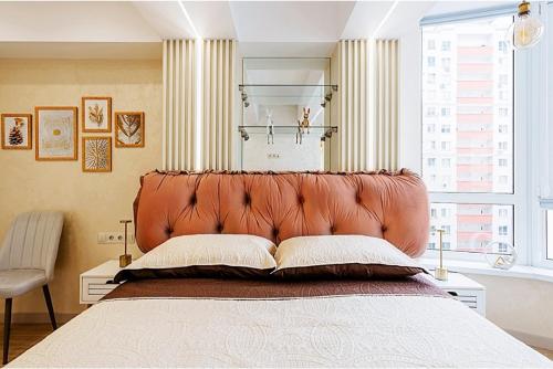 a bedroom with a large bed with a leather headboard at Luxury design Apartment in Chişinău
