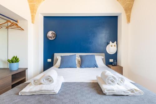 a bedroom with a large bed with blue walls at Villa Demetra by SalentoInVacanzaCOM in Marina di Pescoluse