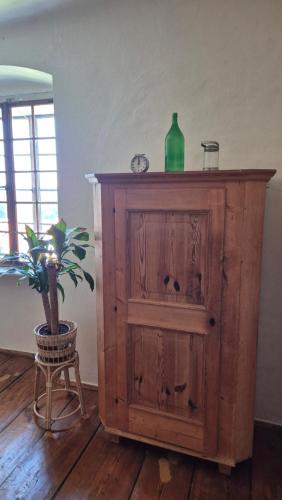 a wooden cabinet with a green bottle and a plant on it at Cool Flat at Renaissance Castle - 2BR in Kalsdorf bei Ilz