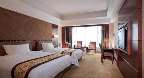 une chambre d'hôtel avec deux lits et une télévision dans l'établissement Vienna International Hotel Dongguan Changping Tian'ehu Road, à Dongguan