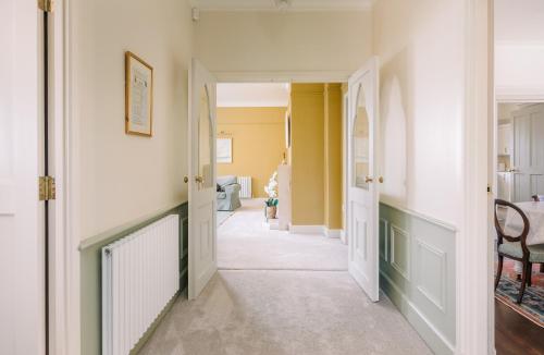 a hallway of a home with yellow walls at NEW JULY 2025 - Grand Clifftop Duplex with Panoramic Views, Games Room & Stylish Interiors in Shanklin Old Village in Shanklin