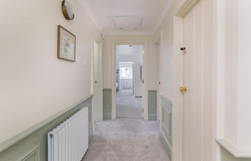 a hallway of a home with white walls at NEW JULY 2025 - Grand Clifftop Duplex with Panoramic Views, Games Room & Stylish Interiors in Shanklin Old Village in Shanklin