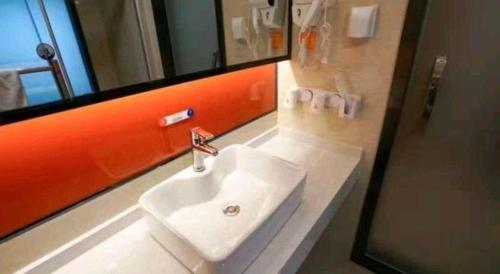 a bathroom with a white sink and a mirror at 7 Days Premium Yancheng Dafeng Zhongjiao Meilu City in Yancheng