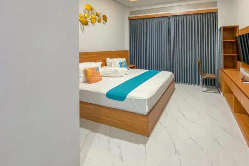 a bedroom with a bed and a television in it at Sans Stay Syariah Asyifa Purwokerto in Purwokerto