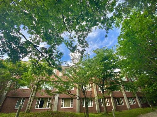a brick building with trees in front of it at Fuji Shoei kaikan in Fuji