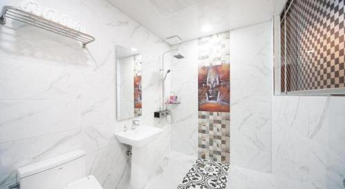 a white bathroom with a sink and a toilet at SH Hotel in Mokpo