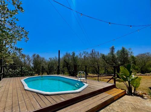 a hot tub sitting on a wooden deck at Villa Eos con Piscina Privata nel cuore del Parco Naturale di Andrano in Andrano