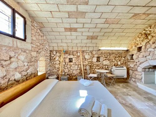 a bedroom with a bed in a stone wall at Villa Eos con Piscina Privata nel cuore del Parco Naturale di Andrano in Andrano