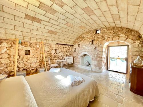 a bedroom with a large bed in a stone wall at Villa Eos con Piscina Privata nel cuore del Parco Naturale di Andrano in Andrano