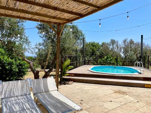 a swimming pool with a deck and a bench at Villa Eos con Piscina Privata nel cuore del Parco Naturale di Andrano in Andrano