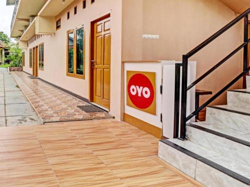 a building with a door with ayno sign on it at OYO 90945 Arizon Kost in Jambi