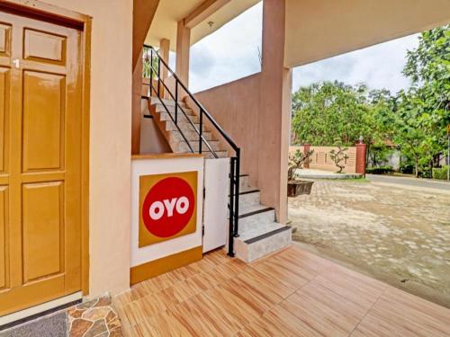 an open door to a house with a omo sign on the wall at OYO 90945 Arizon Kost in Jambi