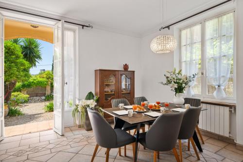 une salle à manger avec une table et des chaises dans l'établissement Villa Mi Rancho Vue mer - Wifi, Parking, Jardin, à Villefranche-sur-Mer