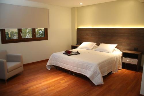 a bedroom with a large bed and a chair at Andares del Agua in Asuncion