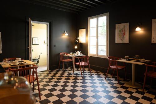 een eetkamer met tafels en stoelen en een raam bij Le Clos du Château in Amboise