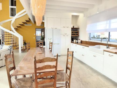 une cuisine et une salle à manger avec une table et des chaises dans l'établissement VILLA HELIOSEA, piscine chauffée, jacuzzi, climatisation, à Léon