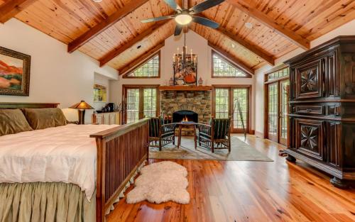 ein Schlafzimmer mit großem Bett und Kamin in der Unterkunft Plummer Lodge - Relax on the porch at this luxury Big Canoe getaway in Jasper