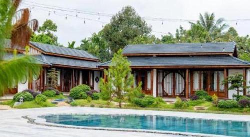 a house with a swimming pool in front of a house at Jun's Home in Buon Ma Thuot