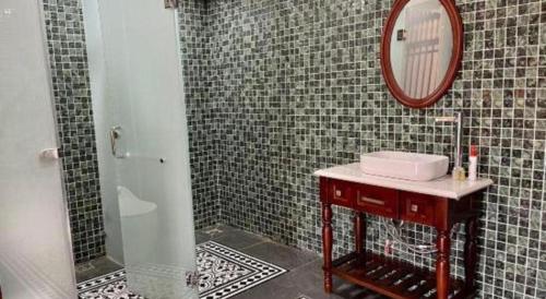 a bathroom with a shower with a mirror and a sink at Jun's Home in Buon Ma Thuot