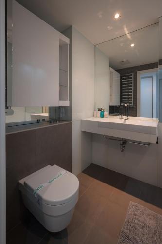 a bathroom with a white toilet and a sink at SKAU Eurovea Duplex Apartment Danube Exclusive View Free Parking in Bratislava