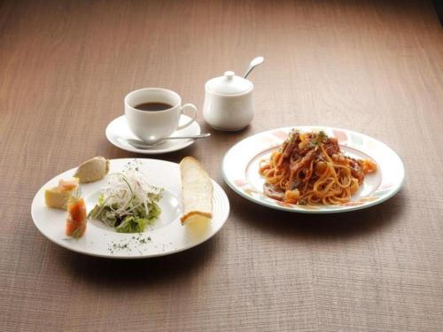a table with two plates of food and a cup of coffee at Hotel Sunoak Kashiwanoha in Kashiwa