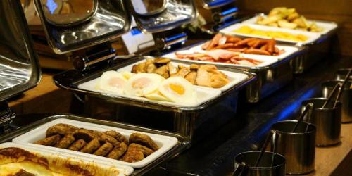 a buffet with several trays of food on a table at APA Hotel Chiba Inzaimakinohara-Ekimae in Narita