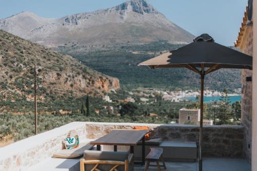 a table and chairs with an umbrella and a view at Brazzo di Maina in Oítilon