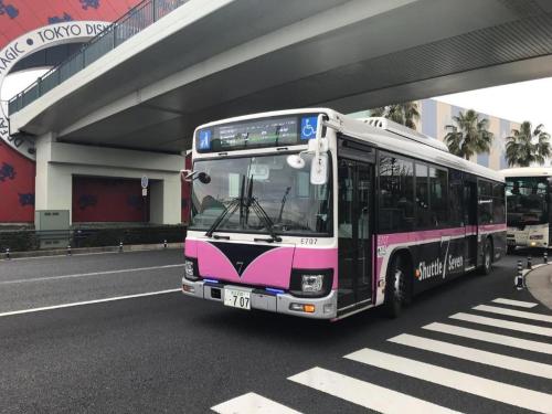 a pink and white bus driving under a bridge at Hotel IL FIORE Kasai in Tokyo