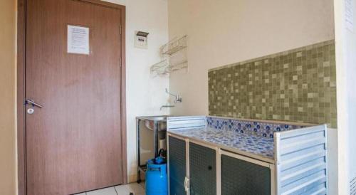 a kitchen with a counter and a wooden door at OYO 94080 Apartemen Podomoro Golf View Palito in Tjikuda Tiga