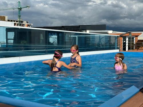 Tres chicas en el agua en una piscina en Apartments 1 line sea WYN RESIDENS, en Batumi