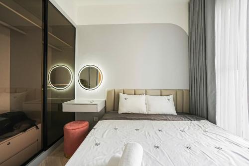 a bedroom with a bed and two mirrors at Homestay Sài Gòn-Luxury Apartment in Long Bình