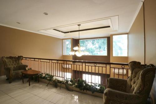 a living room with two chairs and a table at Hotel Permata Bandara in Jakarta