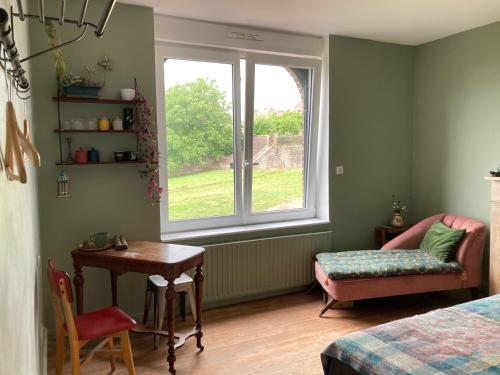 a bedroom with a window and a table and a chair at Belle chambre au coeur de Cassel in Cassel