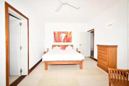 a bedroom with a bed and a wooden dresser at Villa Emerald in Post of Flacq