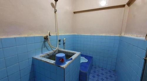 a blue tiled bathroom with a toilet in it at Hotel Sinar Khatulistiwa in Singkawang