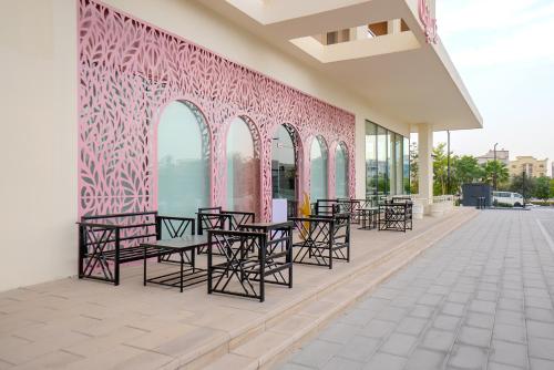 a row of chairs and tables on a building with a pink wall at The Cloud 9 Penthouse by Blue Cloud Holidays in Sharjah Intl