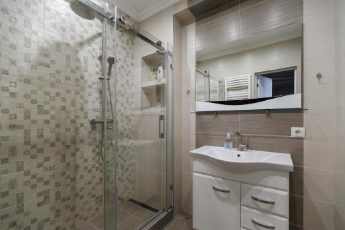 a bathroom with a glass shower and a sink at Zen in Chişinău
