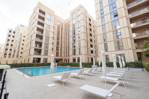 a courtyard with chairs and a pool and buildings at The Cloud 9 Penthouse by Blue Cloud Holidays in Sharjah Intl